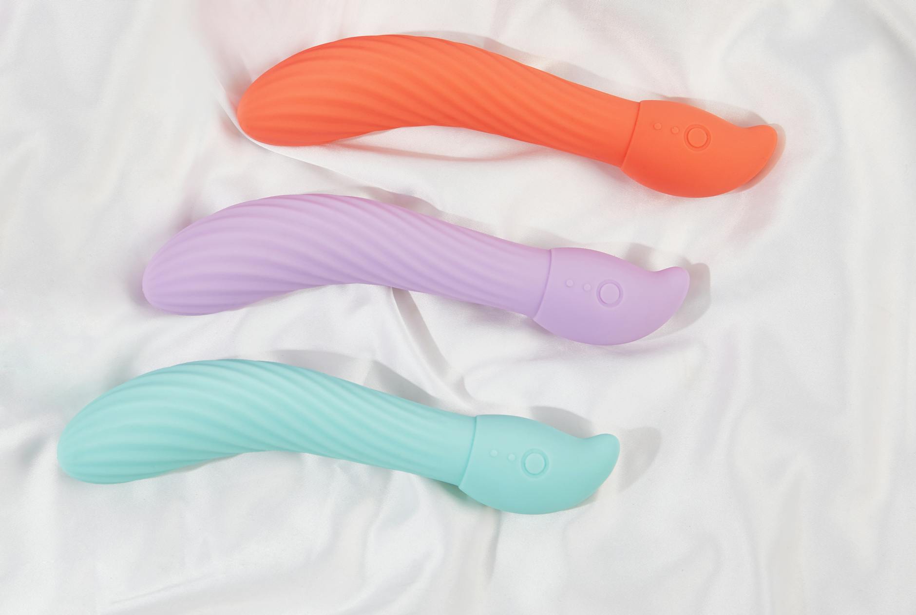 A couple standing together indoors, holding a blue vibrator, symbolizing modern intimacy after parenthood.