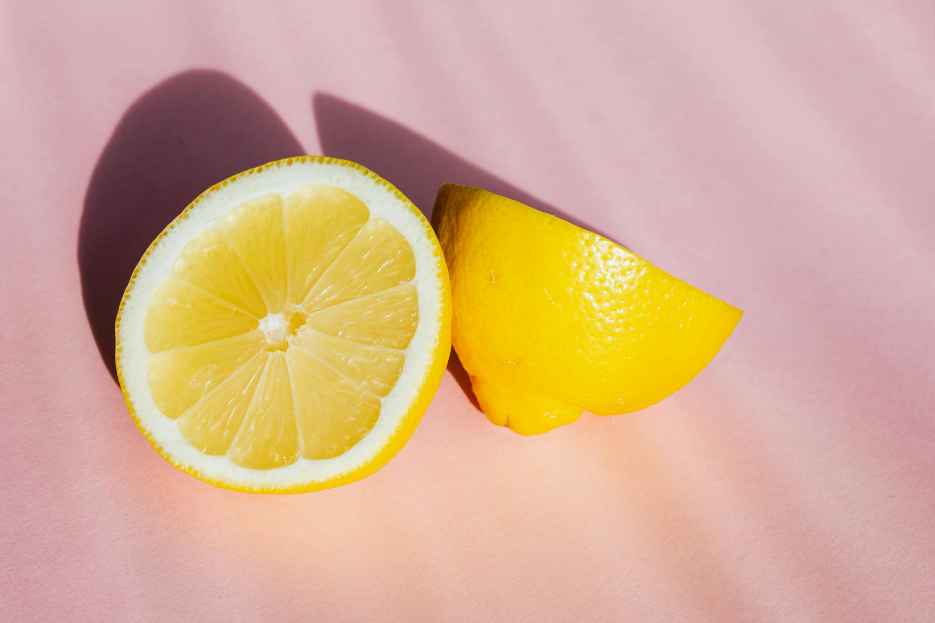 Close-up of a yellow silicone vibrator surrounded by fresh fruit on a bright yellow background