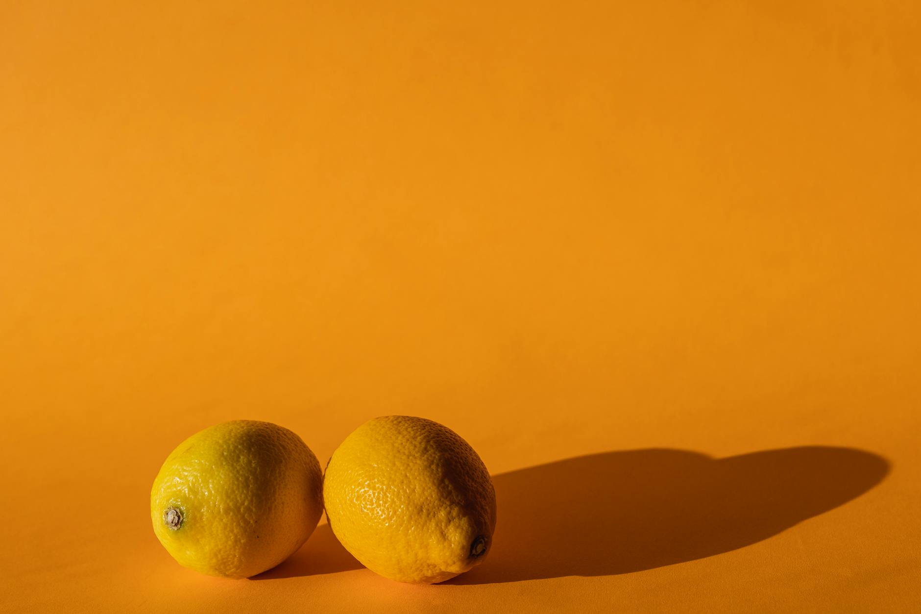 Ripe vivid lemons on a bright yellow background in studio light